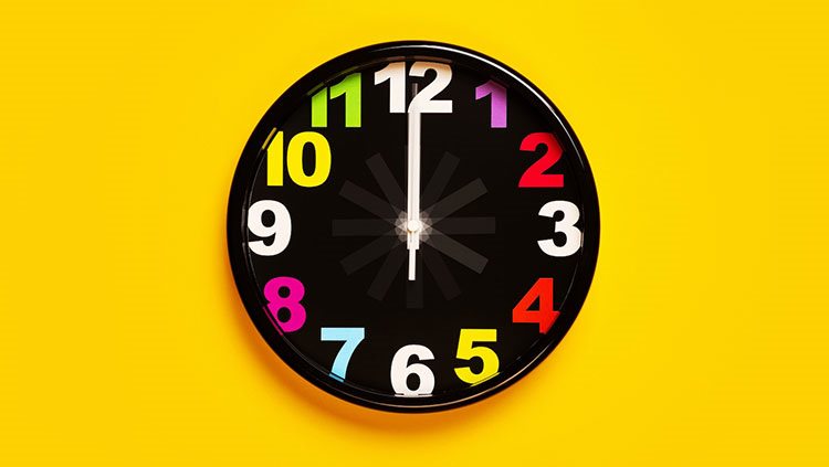 black clock with colorful numbers on yellow background 