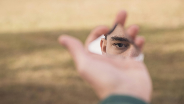 Man holding piece of mirror