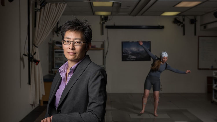 A former undergraduate researcher in the Neuromechanics Lab, Alix Macklin, wears an EEG system while losing her balance on a moving platform.