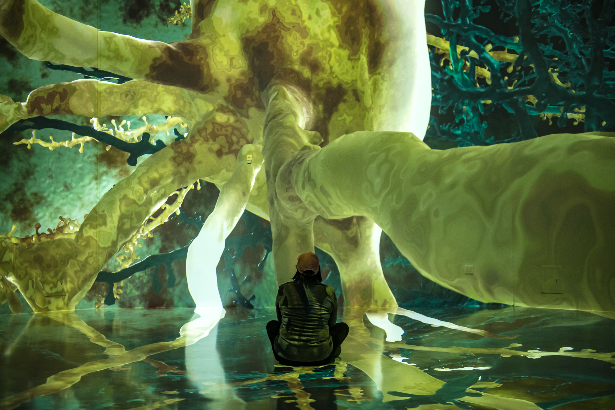 Image of a person sitting on the floor of the main display at the Life of a Neuron exhibit at ARTECHOUSE in Washington D.C.