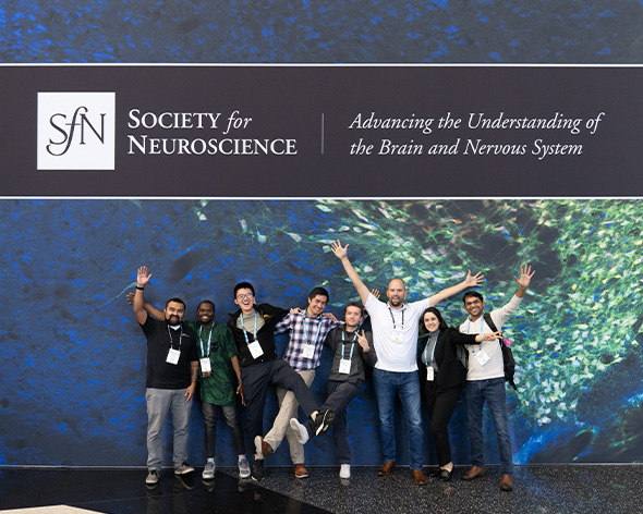 Attendees taking a photo in front of a SfN sign