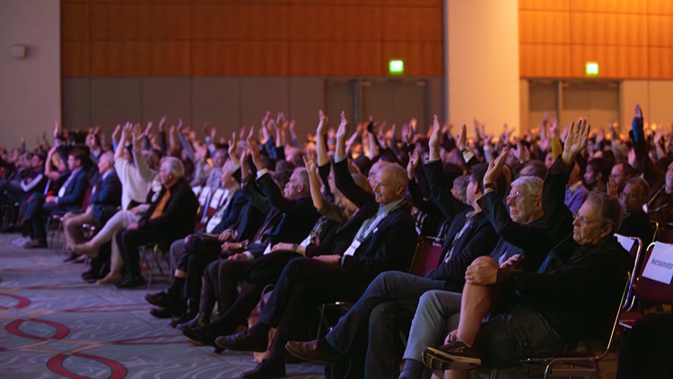 Attendees at Neuroscience 2024 raising their hands