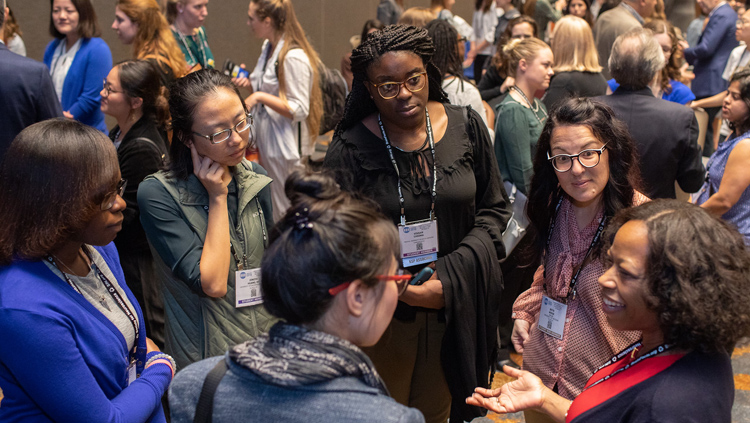 Six women conversing in a circle at the Annual Meeting