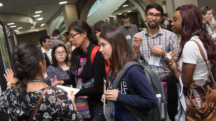 Annual Meeting attendees discussing a poster presentation