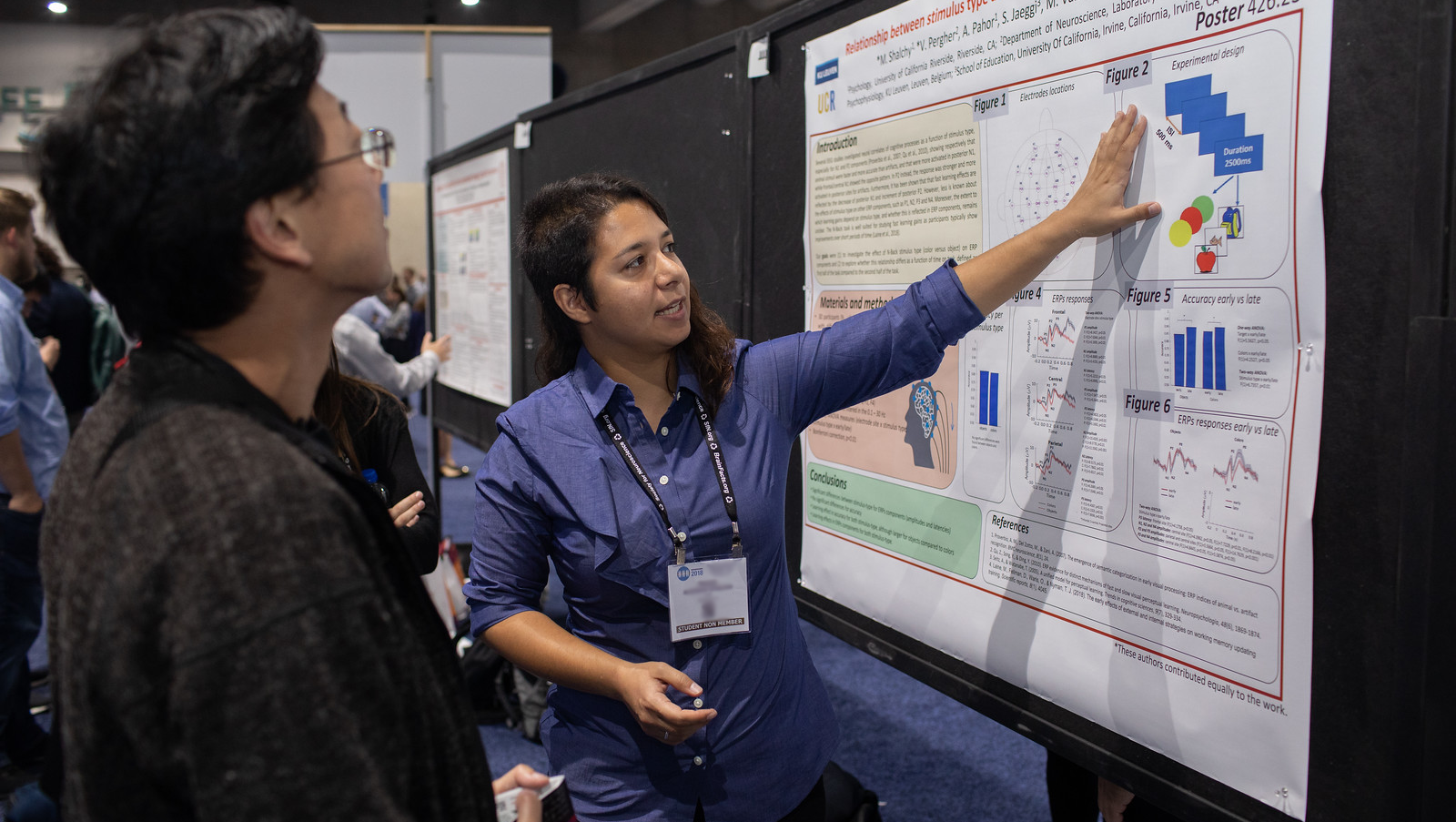 One Neuroscience 2018 attendee explaining poster presentation to another attendee