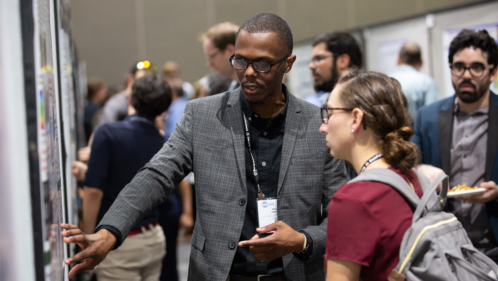 Poster Presenter explaining his work to another attendee at Neuroscience 2018