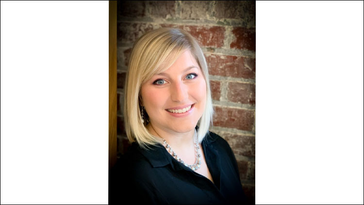 Image of Jenn Honeycutt in front of a brick background.